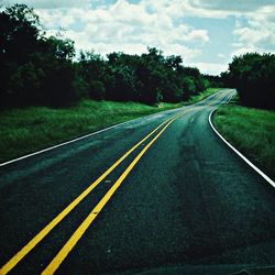 Empty road along trees