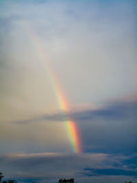 Scenic view of rainbow over sea against sky