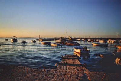 Boats moored on sea against clear sky