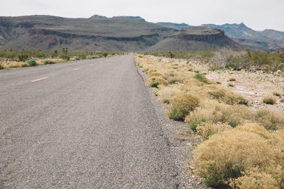 Road amidst desert against sky