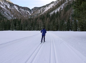 Rear view of man skiing on snow covered mountain