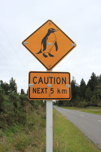 Information sign on road against sky