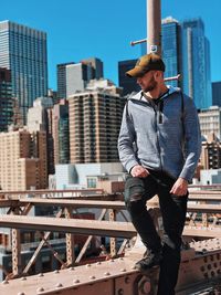 Man standing by modern buildings in city