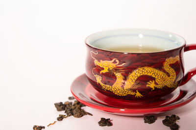 Close-up of tea cup on table against white background