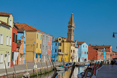 Colorful buildings and boats in front of a canal at burano, a little town full of canals in italy.