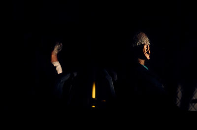 Man and woman standing against black background