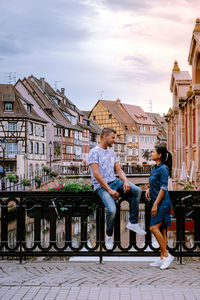 People on buildings in city against sky