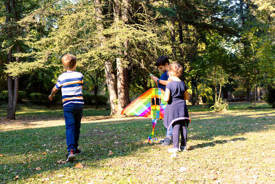 Full length of siblings playing on land