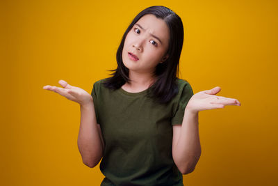 Portrait of woman against yellow background