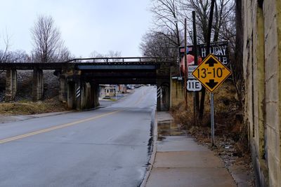 Sign by road against sky