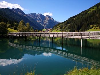 Scenic view of lake and mountains against blue sky