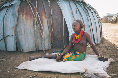 Midsection of woman holding umbrella while sitting on land