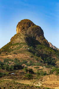 Rock formation on mountain against clear blue sky