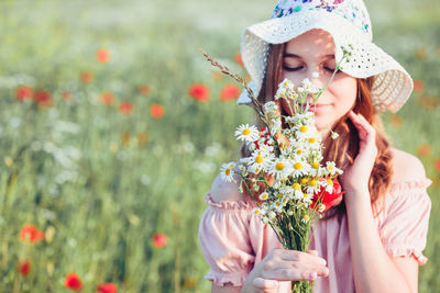 Teenage girl smelling flowers
