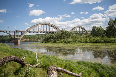 Arch bridge over river against sky