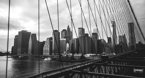 Brooklyn bridge by city skyline against sky