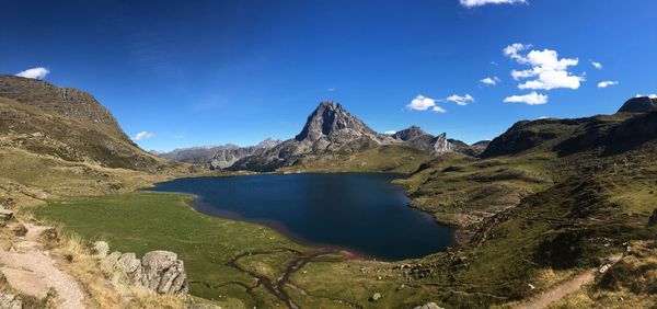 Scenic view of lake and mountains against blue sky