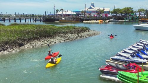 High angle view of people in kayaks on river against sky