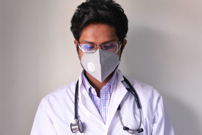 Close-up of doctor wearing mask sitting at office