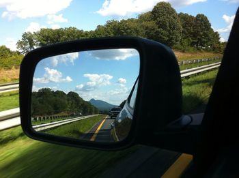 Reflection of clouds in side-view mirror