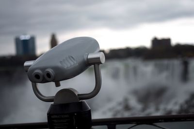 Close-up of coin-operated binoculars against sky
