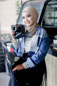 Portrait of woman photographing while sitting in car