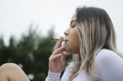 Portrait of young woman smoking cigarette