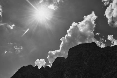 Low angle view of sunlight streaming through clouds