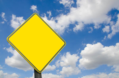 Low angle view of road sign against sky