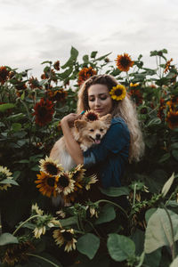 Young woman with dog by plants