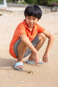 Portrait of boy sitting on sand