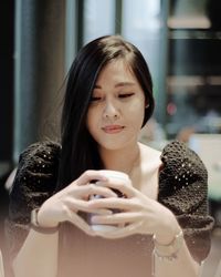 Portrait of young woman using mobile phone