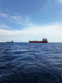 Ship sailing on sea against sky