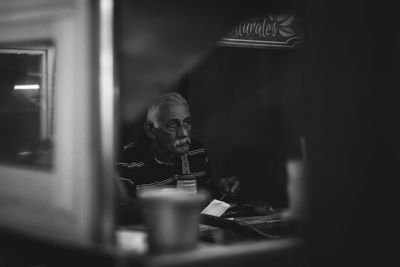 Man looking at camera while sitting on table