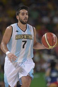 Mid adult man standing against basketball hoop