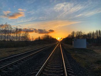 Railroad tracks against sky during sunset