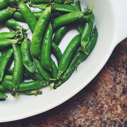 High angle view of green peas in bowl on table