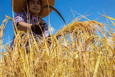 Low angle view of man standing on field against sky