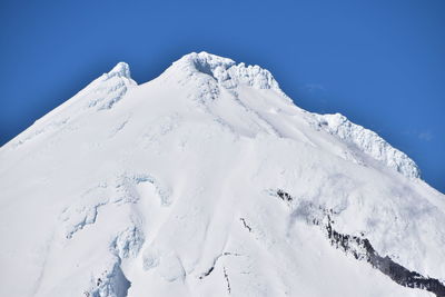 Snow covered mountains against clear blue sky