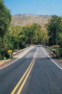 Road amidst trees against sky