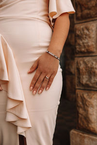 Midsection of woman standing against wall