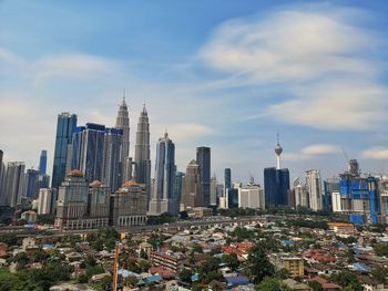 Modern buildings in city against cloudy sky