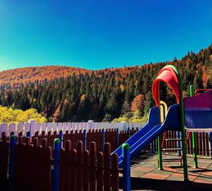 Playground against clear blue sky