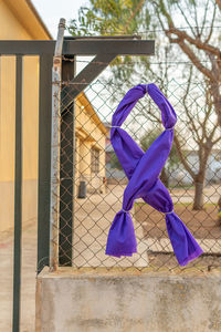 Clothes hanging on chainlink fence against blue sky