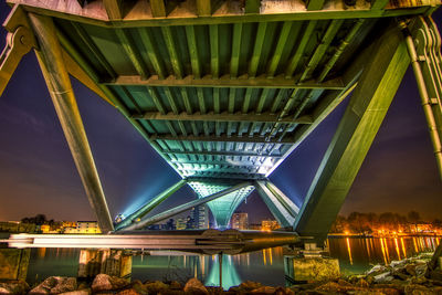 Low angle view of illuminated bridge over river at night