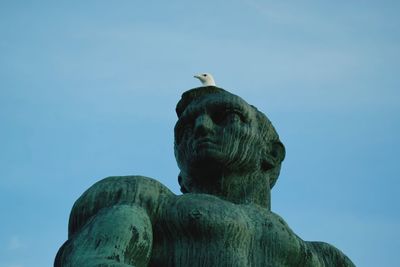 Low angle view of statue against clear blue sky
