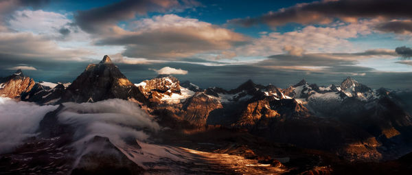 Panoramic view of snowcapped mountains against sky during sunset