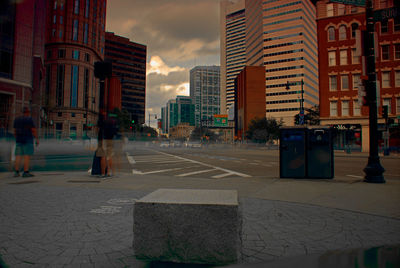 Buildings in city against cloudy sky