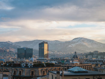 Buildings in city against cloudy sky