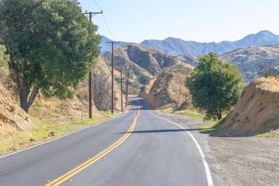 Road amidst plants and mountains against sky